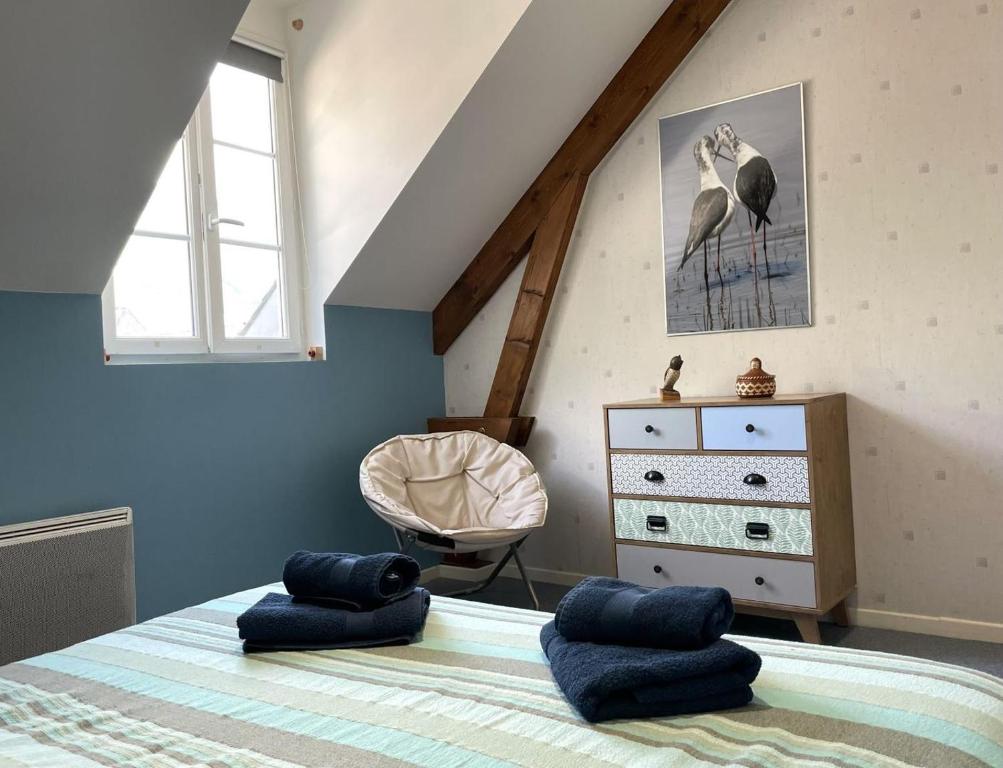een slaapkamer met een bed met blauwe kussens en een dressoir bij TRAVERSIÈRE in Bedous