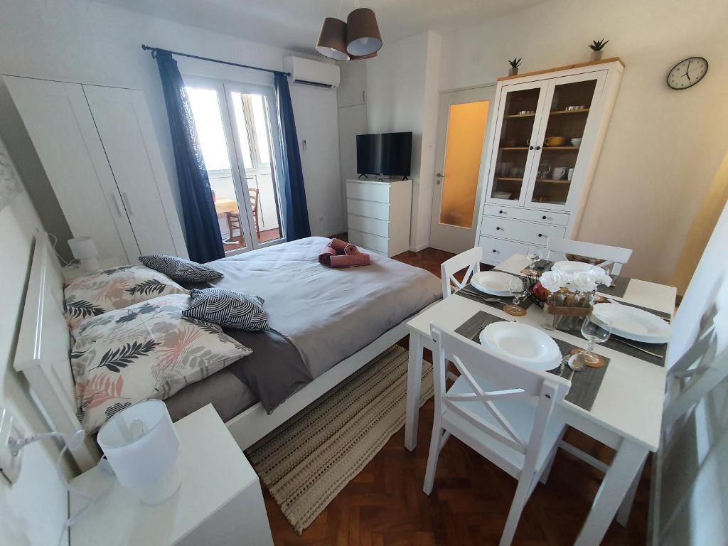 een slaapkamer met een bed, een tafel en een bureau bij Studio Apartman Fredi in Opatija