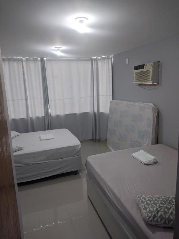 a small bedroom with two beds and a window at Duplex Cabo frio I in Cabo Frio
