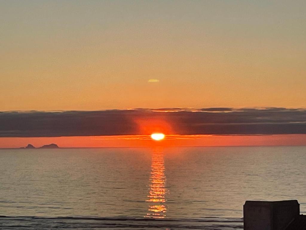 a sunset over the ocean with the sun setting at Foz - Sea View Cottage in Foz do Arelho