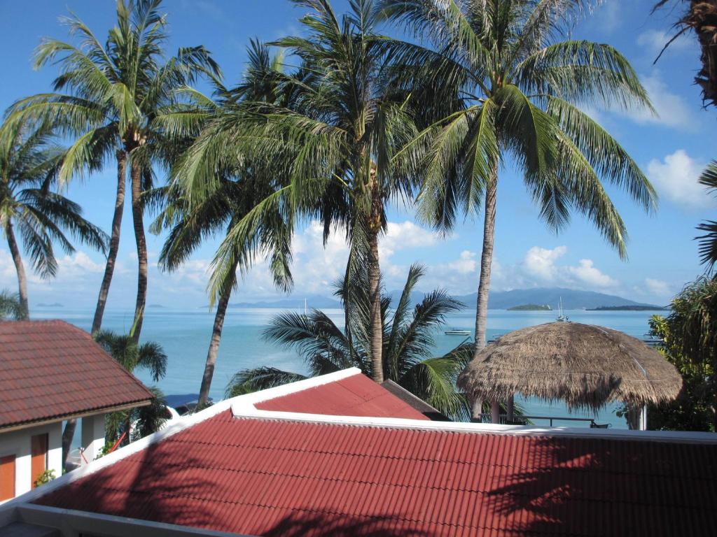 een uitzicht op de oceaan vanuit een resort met palmbomen bij Beach Apartment Samui (Bann Kanchana Bangrak) in Bophut 