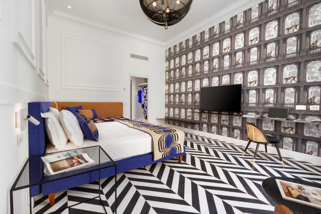 ein Schlafzimmer mit einem Bett und einem TV an der Wand in der Unterkunft YourHome - Maison Iovino Luxury Rooms in Sorrent