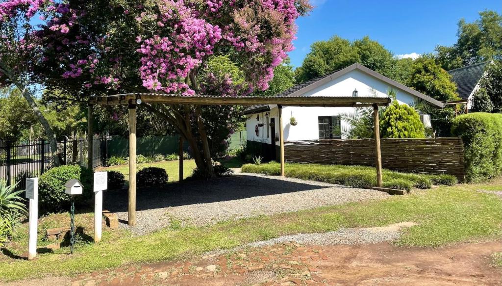 a garden with a pergola in front of a house at The Green Lantern - Howick in Howick