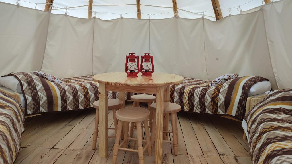 a room with two beds and a table in a tent at Glamping Wild Nature Bałtów in Bałtów