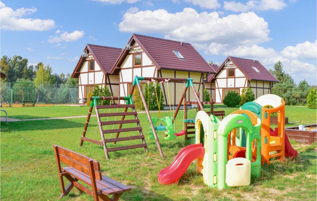 a playground in a yard with a house at Amazing Home In Bialogra With Wifi And 2 Bedrooms in Białogóra