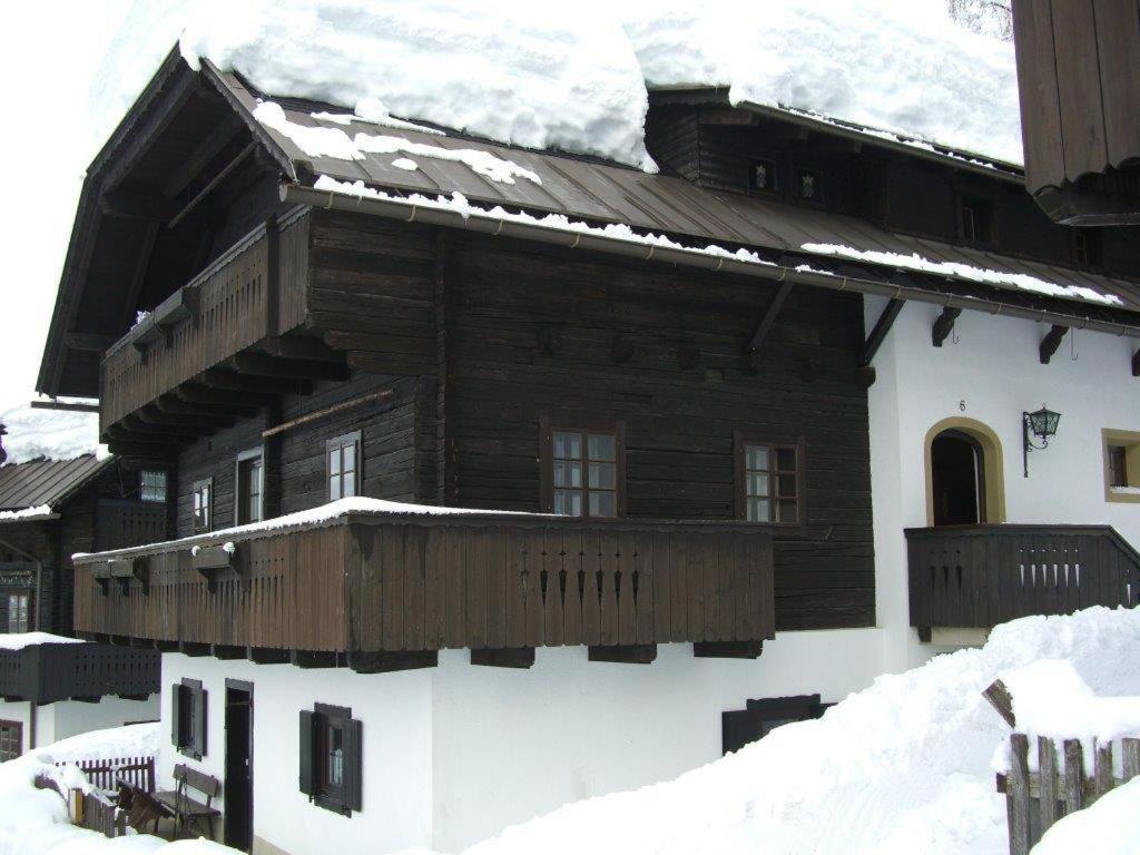 una casa de madera con nieve en el techo en Ferienwohnung Hahn, en Sonnenalpe Nassfeld