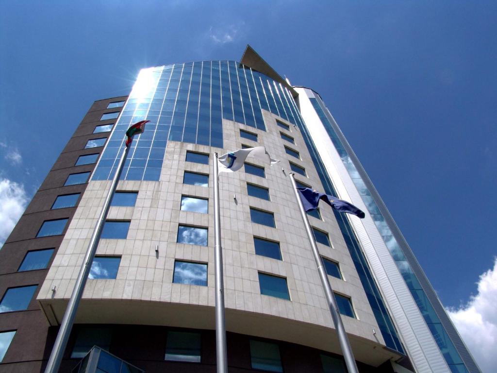 ein hohes Gebäude mit Flaggen davor in der Unterkunft Mirage Hotel in Burgas City