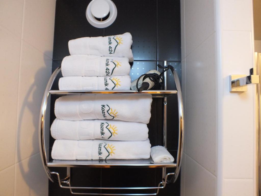 a pile of towels on a towel rack in a bathroom at NevSki Apartments in Kopaonik