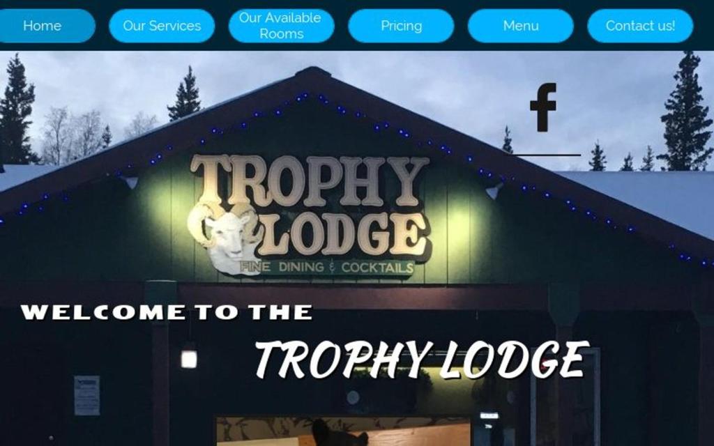 a welcome to the froggy lodge sign on a building at Trophy Lodge Accommodations in Delta Junction