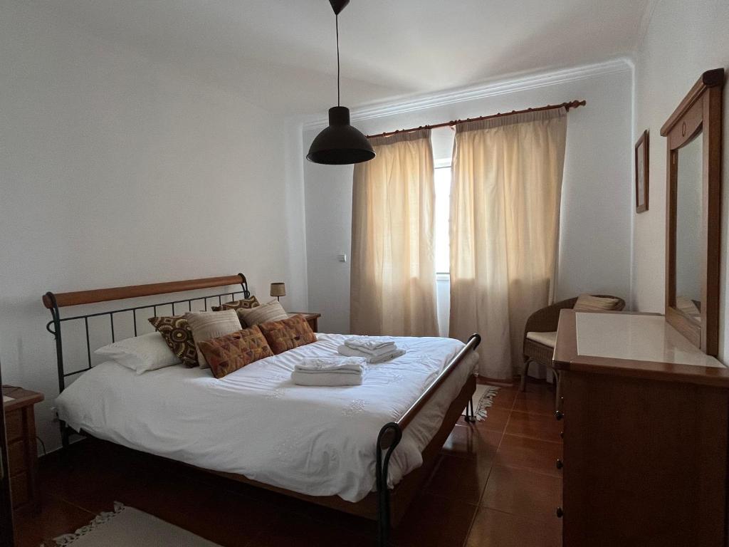 Schlafzimmer mit einem Bett, einem Schreibtisch und einem Fenster in der Unterkunft Azenhas Apartment in Sintra