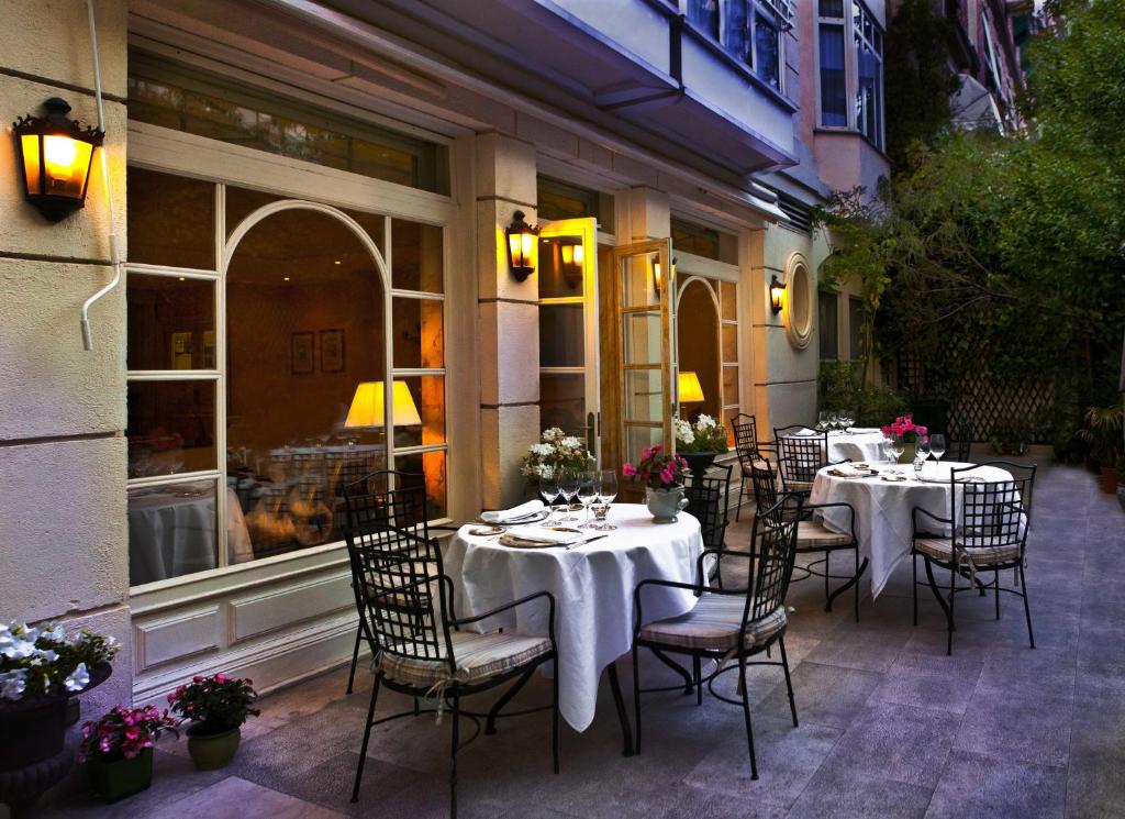 a restaurant with tables and chairs on a patio at Relais & Châteaux Hotel Orfila in Madrid