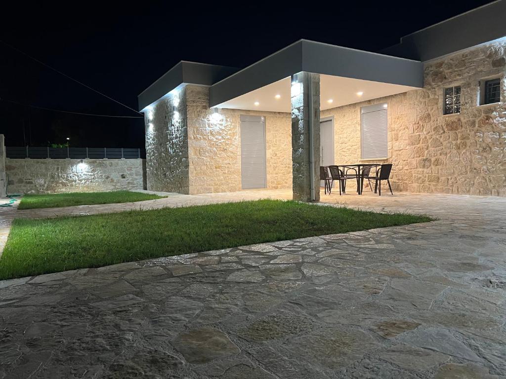 a stone building with a patio at night at AG.Stone.Home in Isthmia