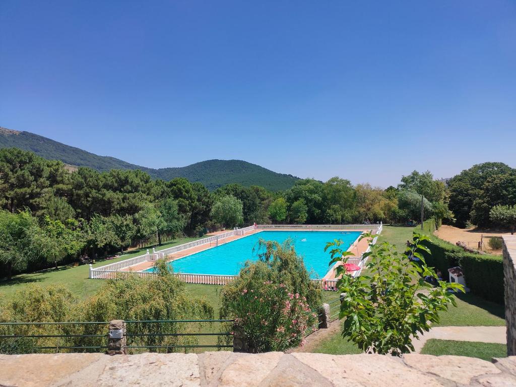 une piscine dans un champ avec des montagnes en arrière-plan dans l'établissement Casa Valentín, à Casillas