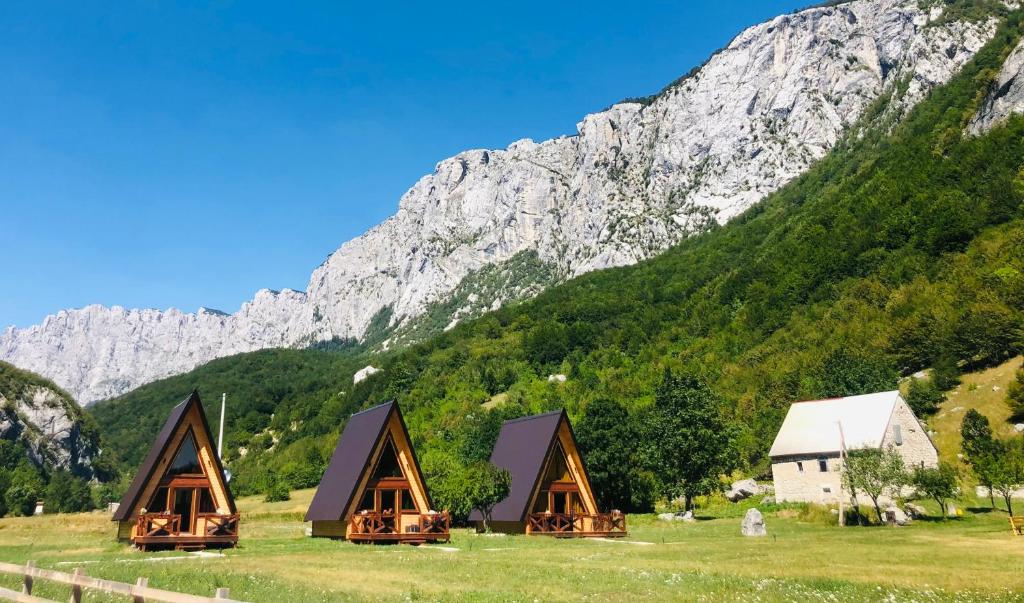 a group of cottages in front of a mountain at Etno apartmani Komarnica in Šavnik