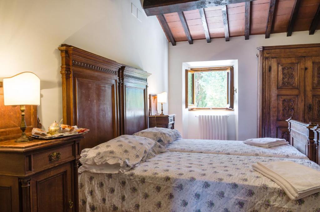 a bedroom with a bed and a dresser with a lamp at Podere San Piero detto "Villa di Grace" in Vaglia