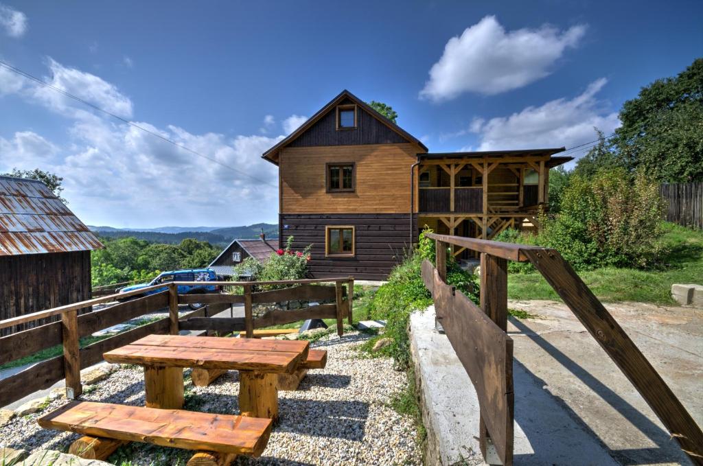 una casa de madera con una mesa de picnic delante de ella en Penzion Pulčiny 43, en Pulčín