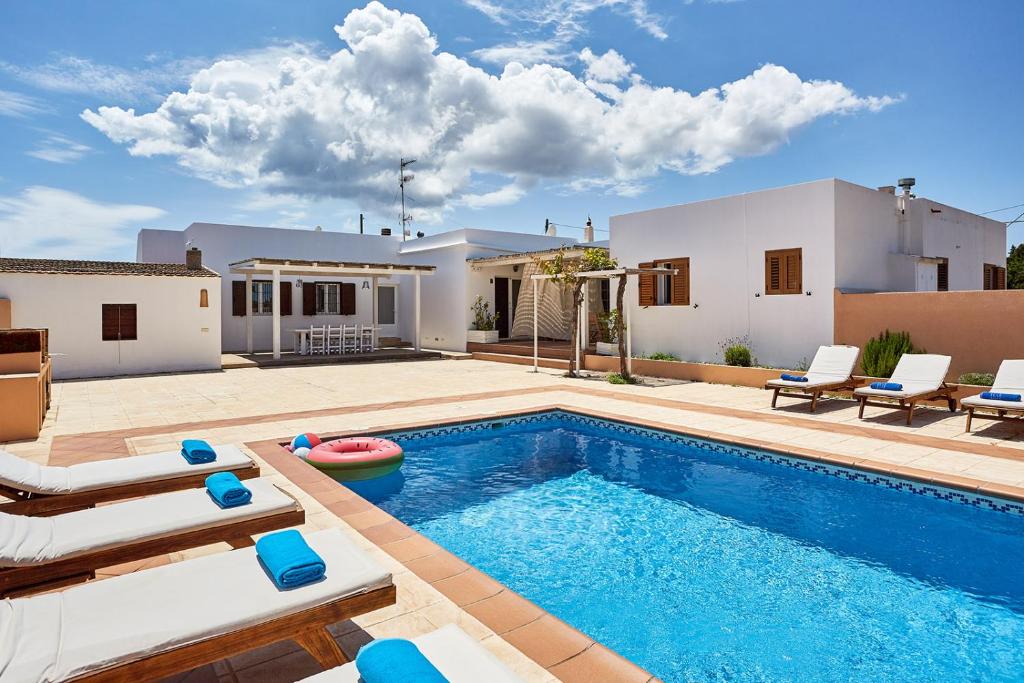 - une piscine avec des chaises et une maison dans l'établissement V Es Pujols Formentera rustick, à Es Pujols
