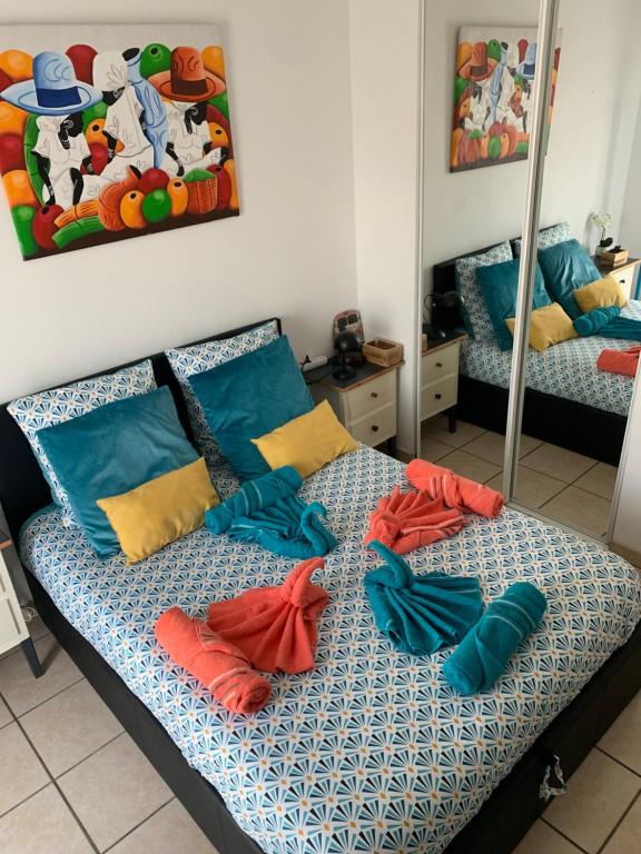 - un lit avec des oreillers bleus et oranges dans l'établissement LES HAUTS DE BIANTENIA AVEC WIFi, à Hendaye
