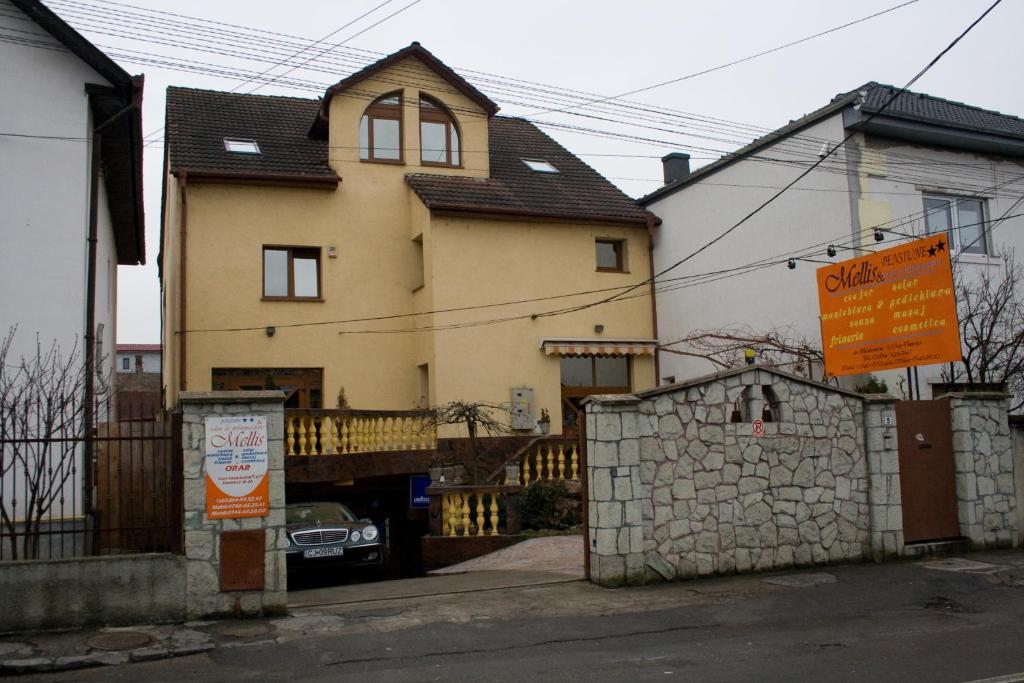 una casa con un cartello davanti di Pension Mellis Cluj Napoca a Cluj-Napoca