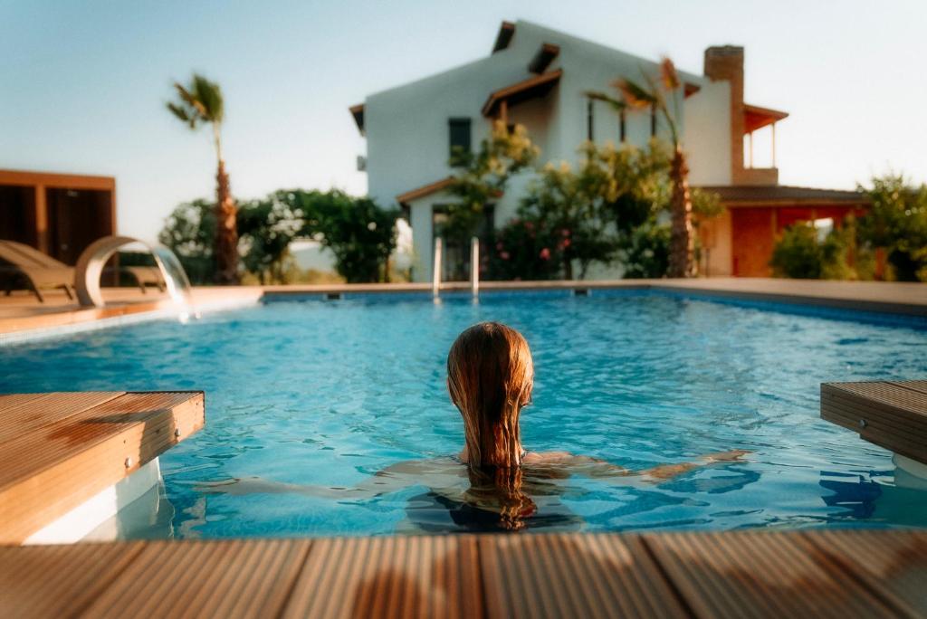 een vrouw zit in een zwembad bij Ali Baba Ciftligi Boutique Hotel in Alacati