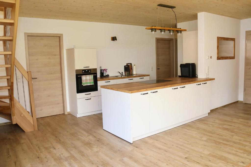 cocina con armarios blancos y encimera de madera en BaumKrone im Happy Allgäu - 2-stöckige Wohnung mit Wohnnetz en Leutkirch im Allgäu