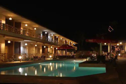 a large swimming pool in a hotel at night at Bamboo Garden Hotel in Serekunda