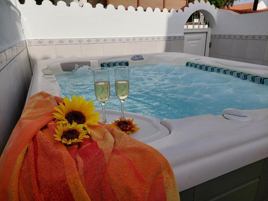 two glasses of champagne and sunflowers in a hot tub at Jacuzzi House Sunflower in Costa Del Silencio