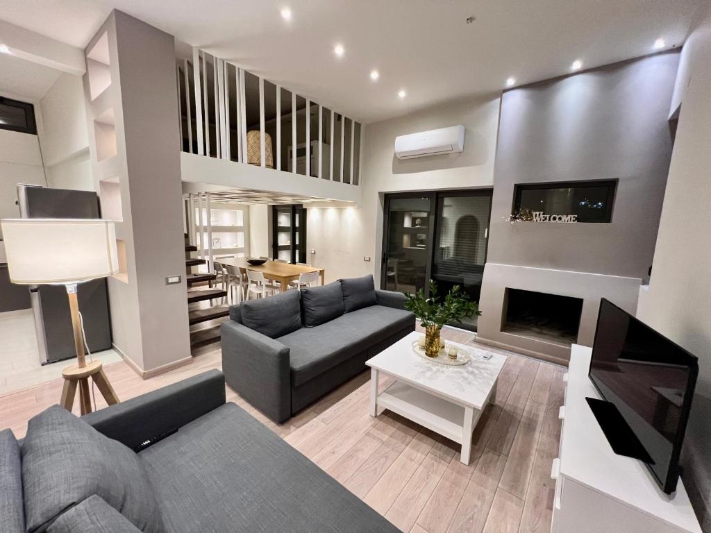 un salon avec un canapé et une table dans l'établissement Victoria's Luxury Apartment - Fireplace, Jacuzzi, Private pool, à Agios Nikolaos