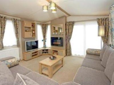 a living room with a couch and a table at Roxbury 5 Star 6 berth Luxury Caravan in Exeter