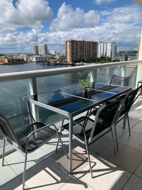 a table and chairs on a balcony with a view of the water at Beautiful Miami Place in Miami Beach