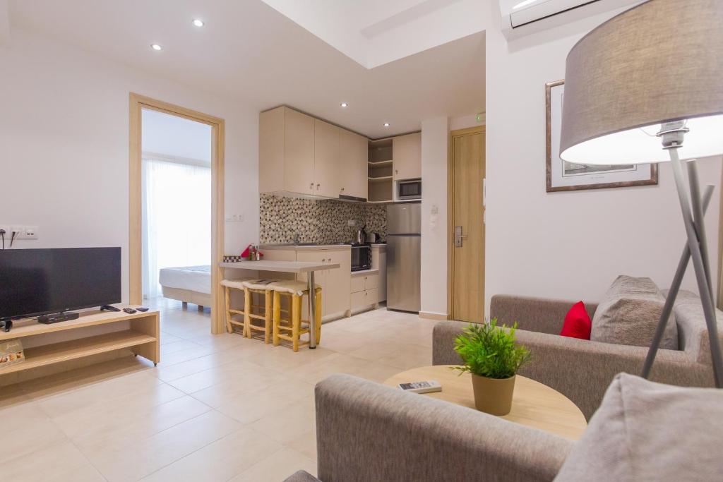 een woonkamer met een bank en een tv en een keuken bij The Perfect Spot Apartments in Rhodos-stad