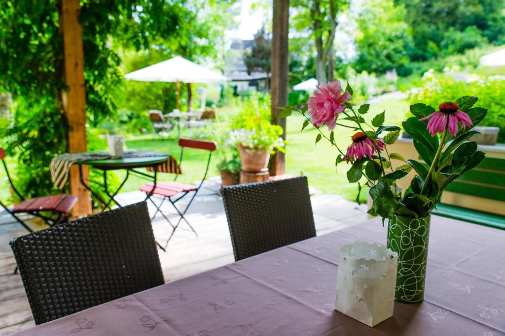 una mesa con un jarrón de flores sobre una mesa en Landhaus Arztmann en Bodensdorf