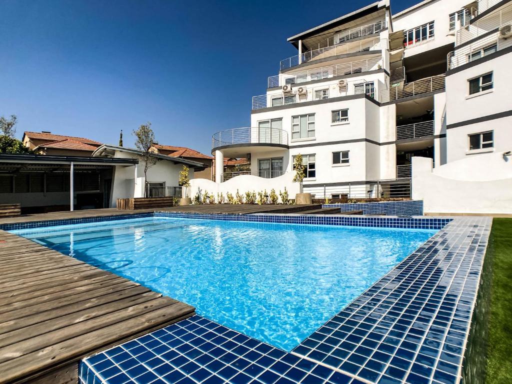 una piscina frente a un edificio en Splice Apartments en Johannesburgo