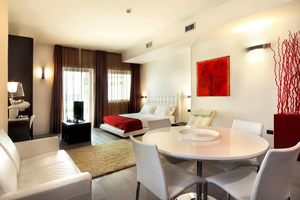un soggiorno con tavolo, sedie e letto di Mediterraneo Palace Hotel a Ragusa