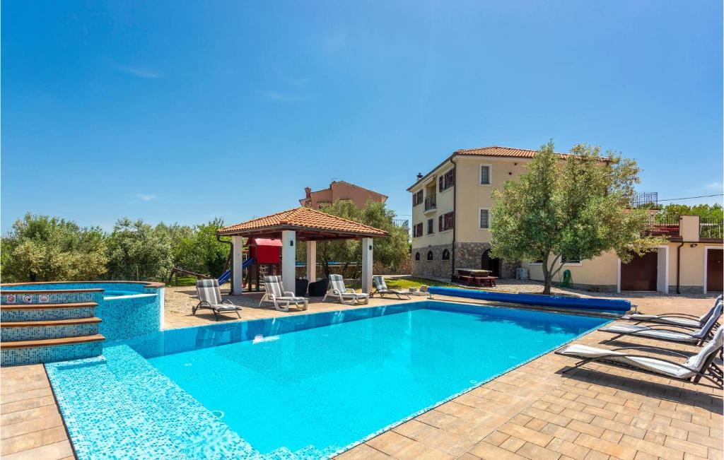 a swimming pool with chairs and a gazebo at Gorgeous Home In Sveti Vid Dobrinjski With House A Panoramic View in Gostinjac