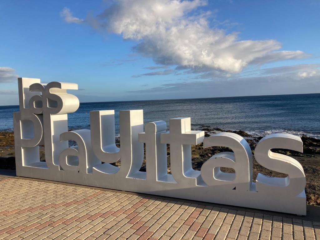 a large metal sign that reads the beach at Apartamento MAFASCA in Las Playas