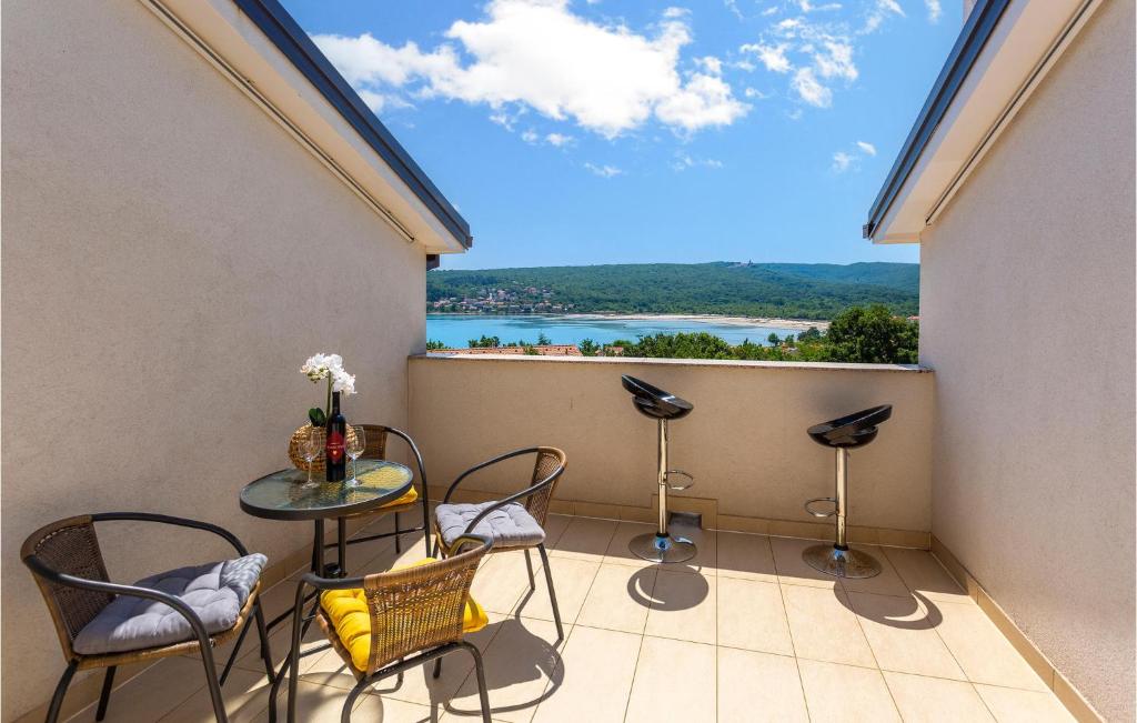 d'un balcon avec une table et des chaises et une vue. dans l'établissement 3 Bedroom Cozy Apartment In Dobrinj, à Dobrinj