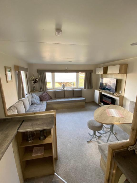 sala de estar amplia con sofá y mesa en Modern & Homley 3BR Caravan, en Hastings