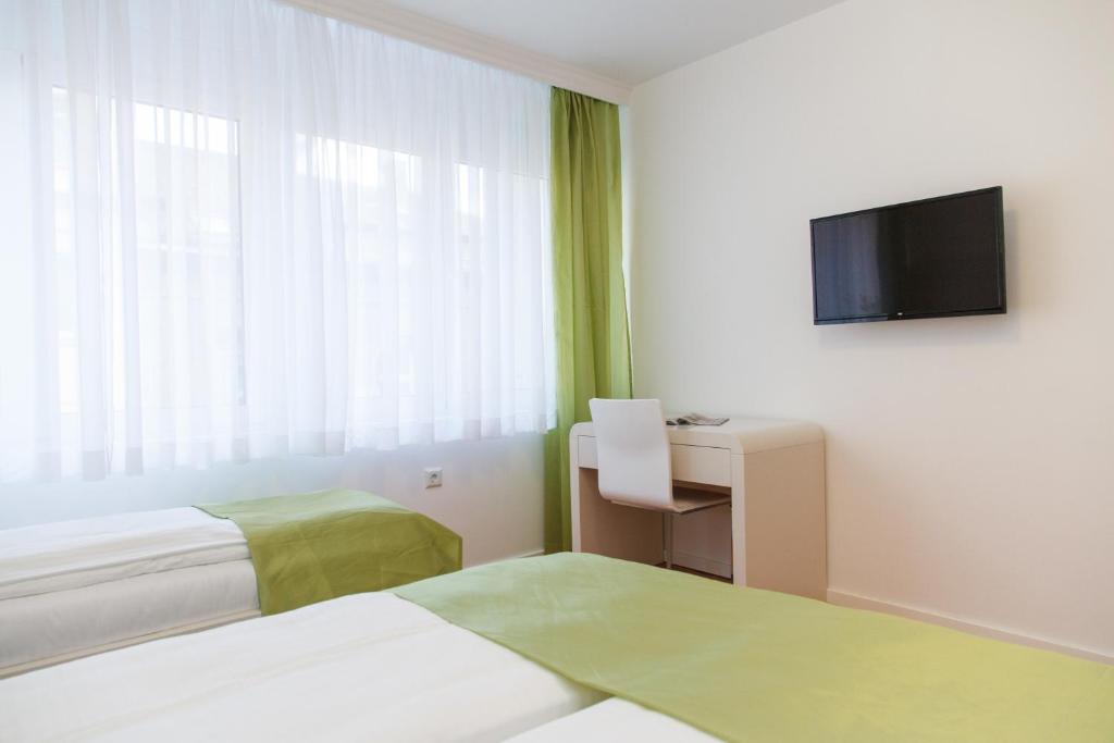 um quarto de hotel com uma cama e uma televisão em Apartment Jovanova em Belgrado