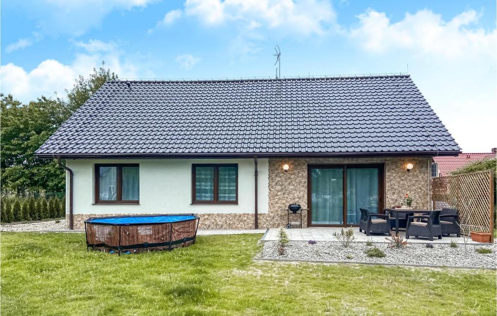 a house with a table and chairs in a yard at Stunning Home In Wiselka With 3 Bedrooms, Wifi And Outdoor Swimming Pool in Wisełka
