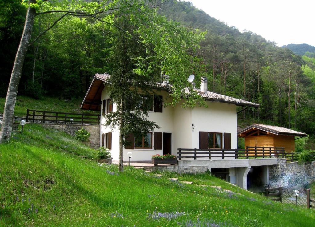 a house in the middle of a grassy hill at Casa Aldo Lago di Ledro in Ledro