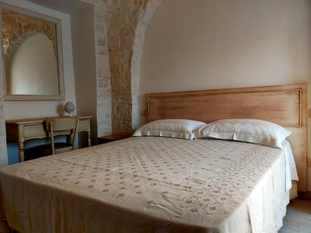 una camera da letto con un grande letto con due cuscini di I trulli di Nonno Battista a Locorotondo