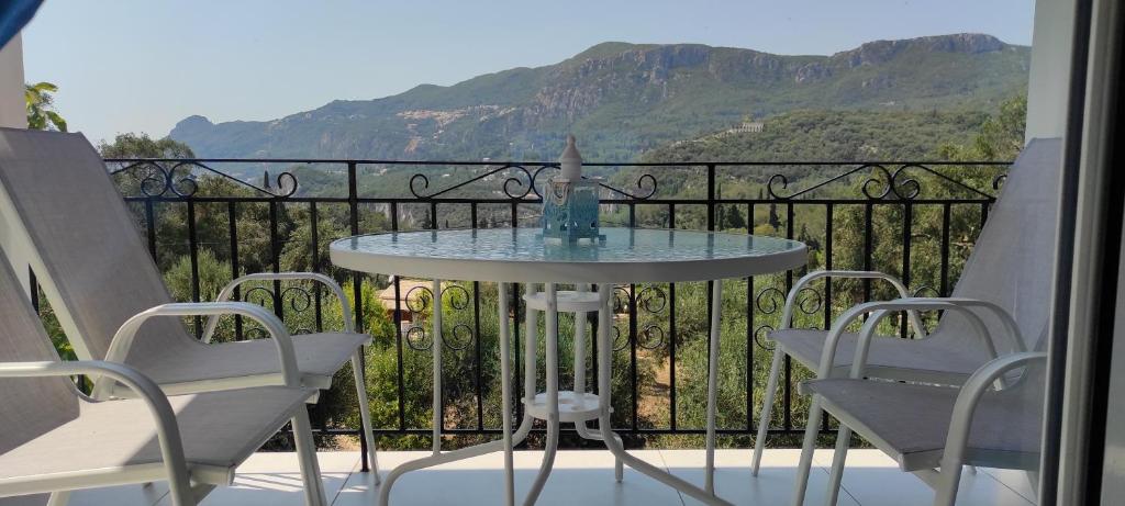 einen Tisch und Stühle auf einem Balkon mit Aussicht in der Unterkunft Corfu Sunset apartment in Liapades