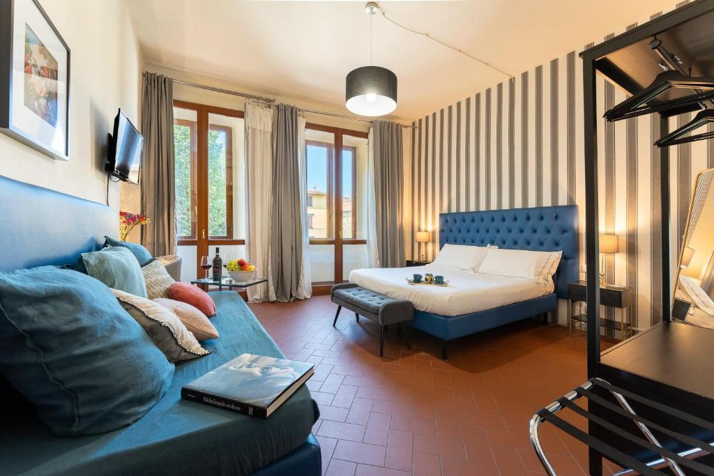 a living room with a blue couch and a bed at SPIRIT OF FLORENCE Boutique Rooms in Florence