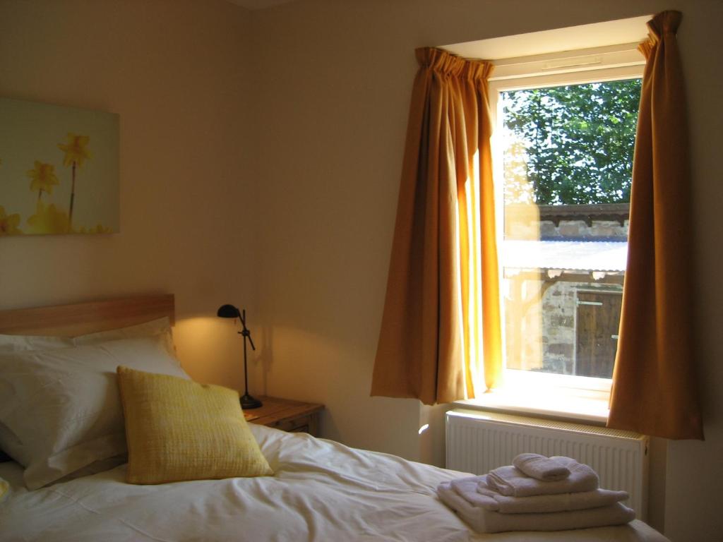1 dormitorio con cama y ventana en Seggat Farm Holiday Cottages, en Kirktown of Auchterless