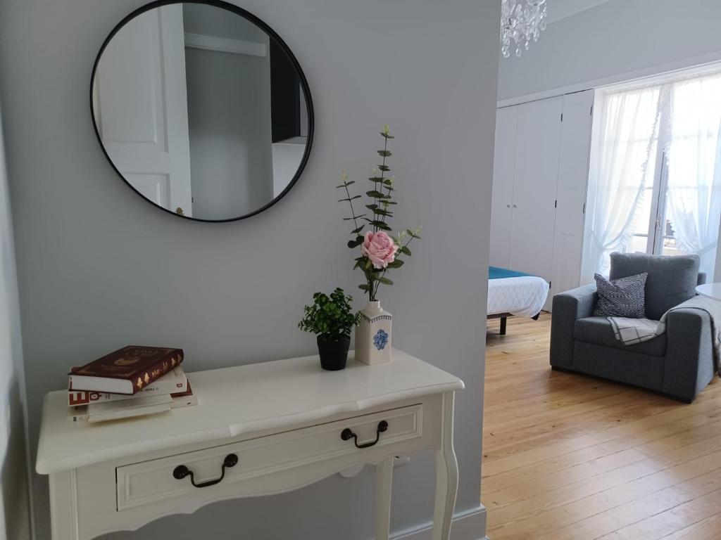 a living room with a table with a mirror on the wall at Suites do Doutor in Pombal