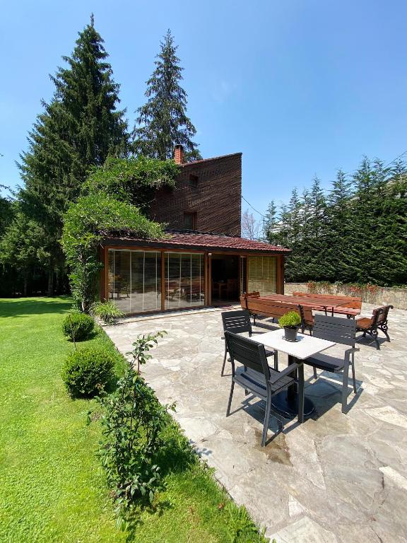 a patio with a table and benches in a yard at Brezovica Luxury Villa in Brezovica