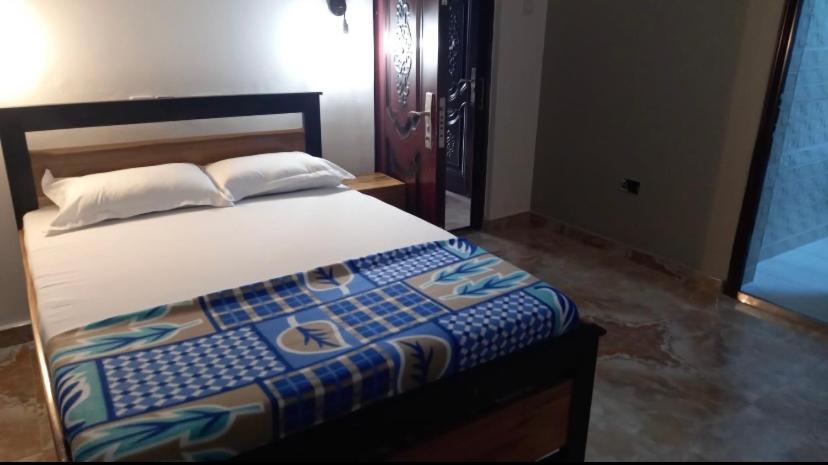ein Schlafzimmer mit einem Bett mit einer blauen und weißen Decke in der Unterkunft BAFFOUR STUDIO in Kumasi