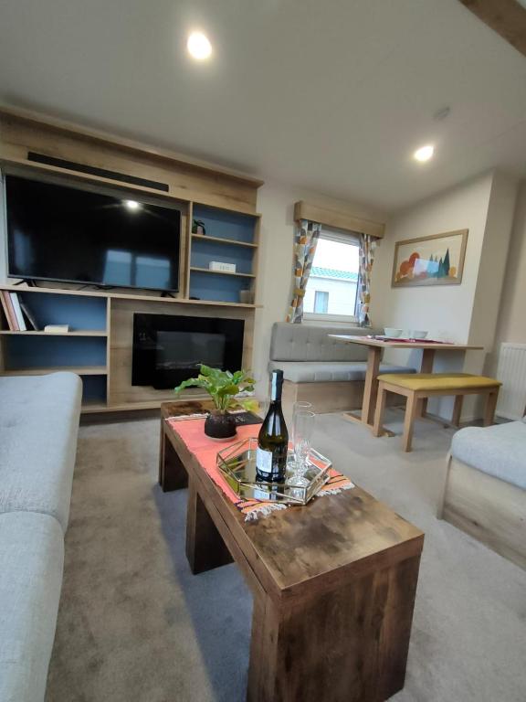 a living room with a bottle of wine on a table at Luxury 3 Bedroom Caravan Near Edinburgh in Port Seton