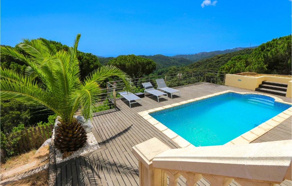 a villa with a palm tree and a swimming pool at Nice Home In Sant Cebria De Vallalt in Sant Cebrià de Vallalta